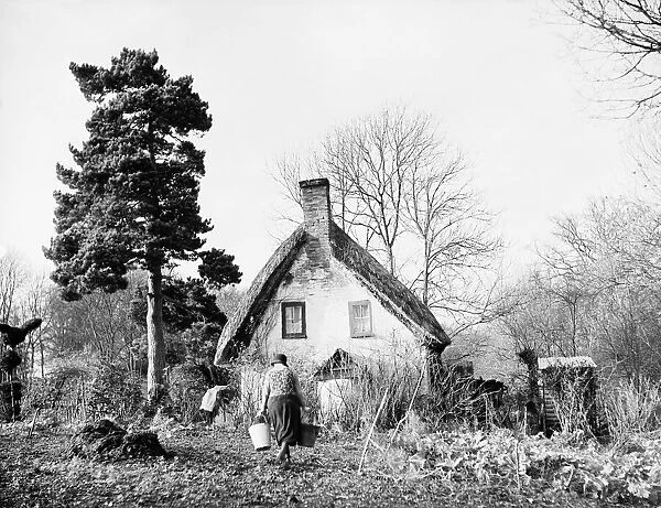 Women carrying buckets of water to her rural cottage, far from the world