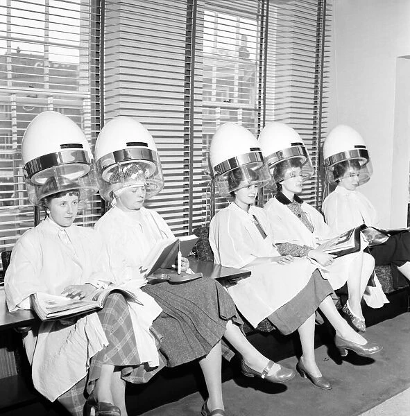 Women at the hairdressers seen here under the driers. April 1956
