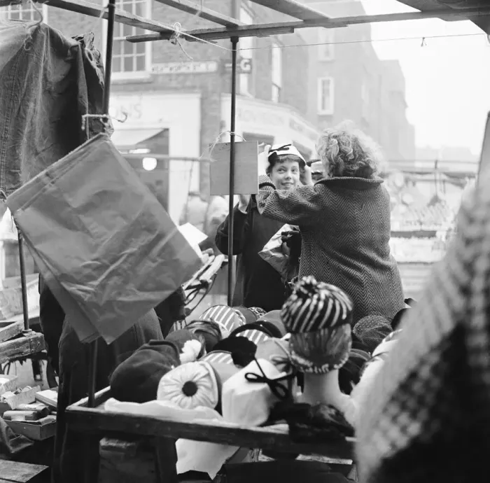 Framed Print : Women out looking for a bargain on the milliner stall at Petticoat Lane Market Framed Print : Women out looking for a bargain on the milliner stall at Petticoat Lane Market
