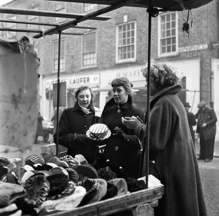 Framed Print : Women out looking for a bargain on the milliner stall at Petticoat Lane Market Framed Print : Women out looking for a bargain on the milliner stall at Petticoat Lane Market