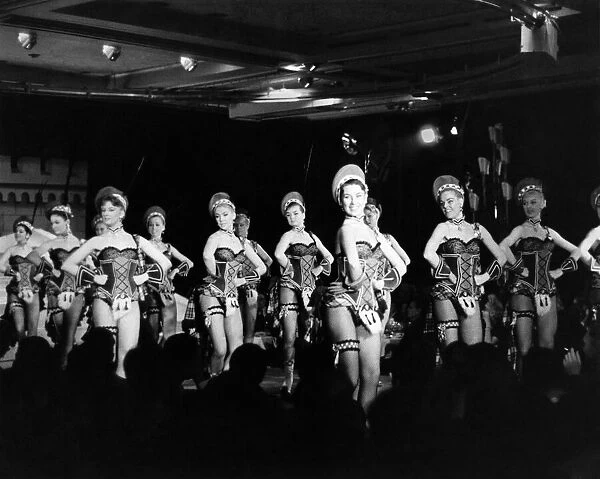Women performing a dance routine on stage at a Paris night club