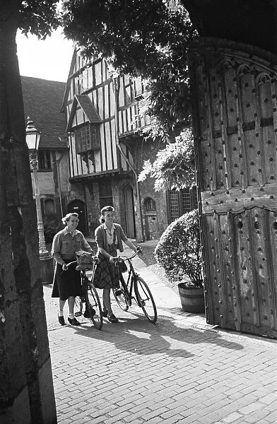 Two women pushing their bicycles through Cheyneys Court in Winchester, Circa 1945