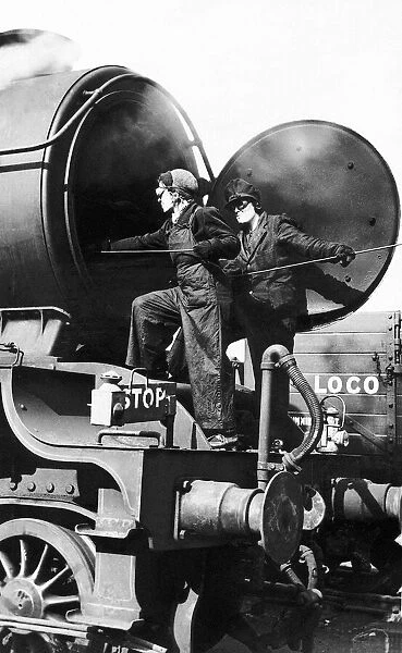 Women railway workers clean out a steam engine boiler during WW2. 1942