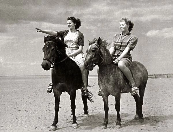 Two women out riding their horses on the beach at Hunstanton in Norfolk at the start of
