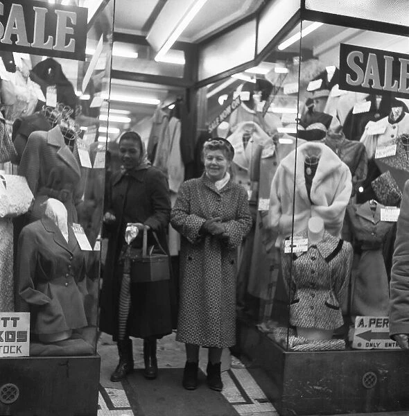 Two women shoppers peruse the garments for sale in a un-named East End clothes shop