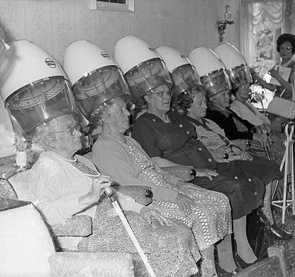Women sitting at stand hair dryers in a salon