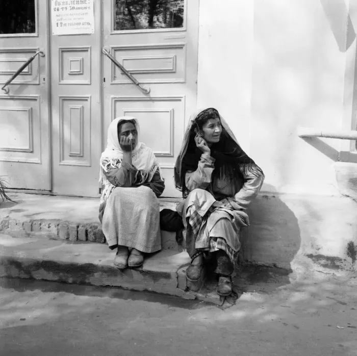 Framed Print : Two women sitting on the steps of a shop watch the May Day parade in the Russian town of Framed Print : Two women sitting on the steps of a shop watch the May Day parade in the Russian town of