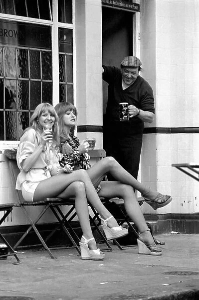 Two women stop at a pub to have a pint of beer while shopping on Kings Road in Chelsea