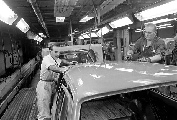 Worker Albert Moss (in white coat) and J. Barrow working on sanding Cortinas in Fords