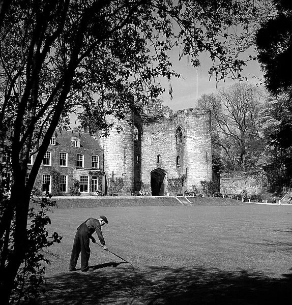 A worker cleaning the grounds outside Tonbridge Castle in Kent May 1952