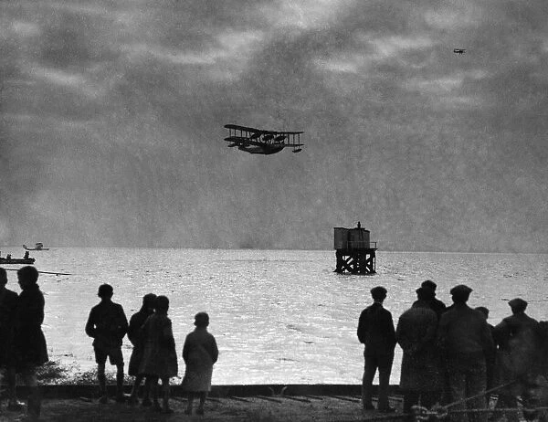 Workers at Brough watch a Blackburn Perth aircraft of 209 Squadron seen here during a