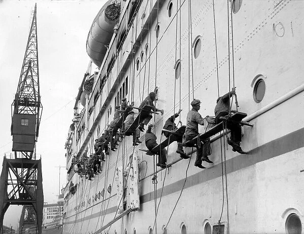 Workers cleaning the Empress of Australia liner at Southampton dock following