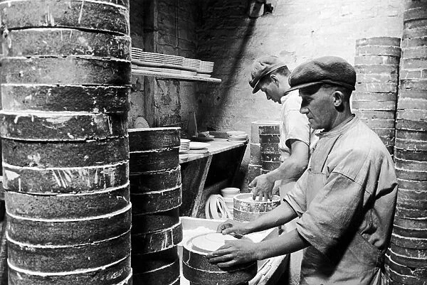 Workers at the Minton China Works in Stoke On Trent, set plates in 'saggars'