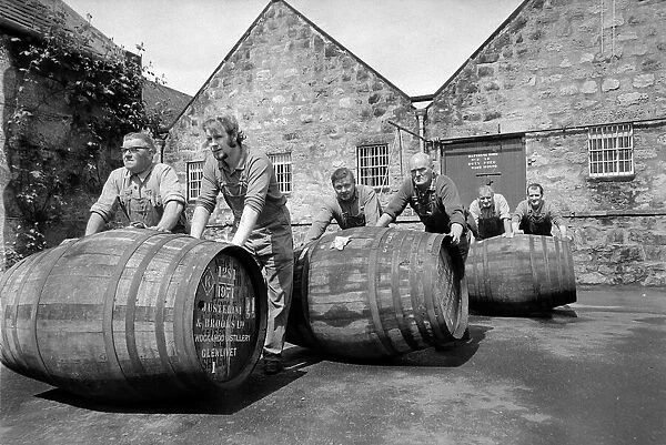 Workers rolling barrels of Whisky to the bonded warehouse at the Knockando Whisky