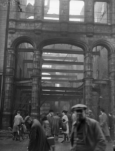 Workers survey the burnt out shell of W. H. Smith in Station Street