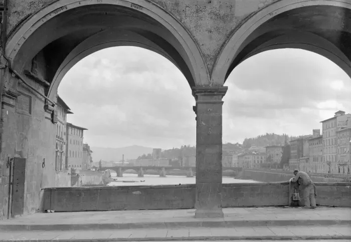 Framed Print : A workman fills his bucket from a public tap on the Ponte Vecchio bridge that spans Framed Print : A workman fills his bucket from a public tap on the Ponte Vecchio bridge that spans