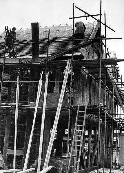 Workmen in action roofing old houses from Much Park Street, Coventry