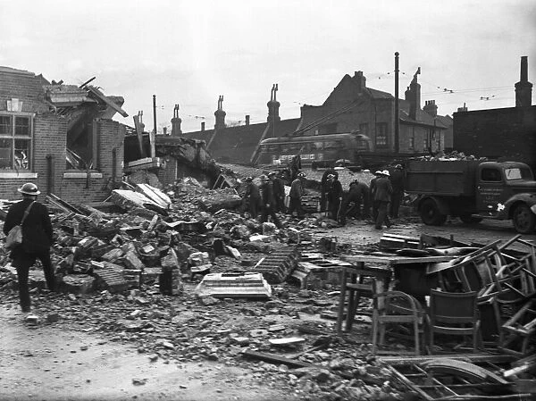 Workmen clear away the rubble following an air raid on Putney, London