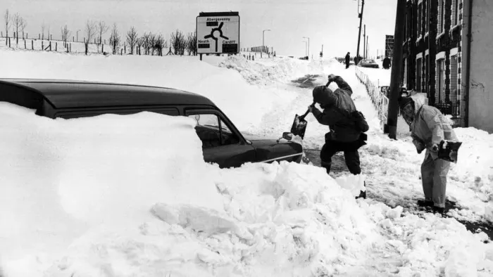 Framed Print : Workmen dig out a van from the blocked High Street, Dowlais. 27th April 1981