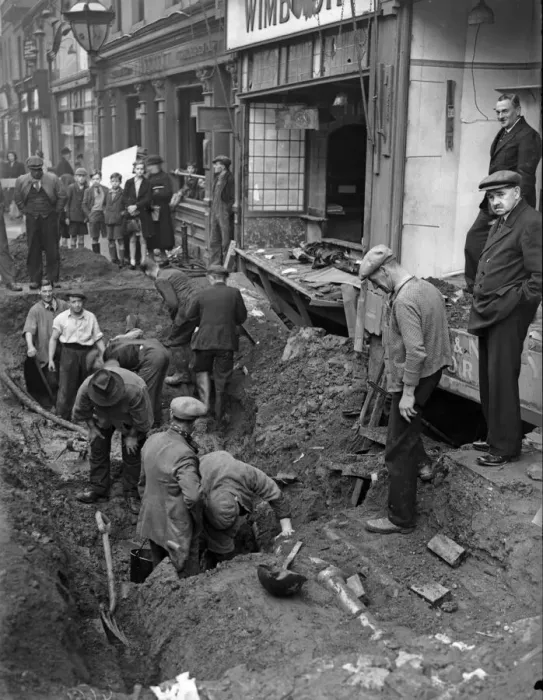 Framed Print : Workmen inspect a crater in central Birmingham following a raid on the city Framed Print : Workmen inspect a crater in central Birmingham following a raid on the city