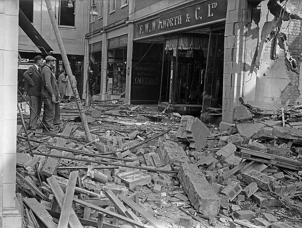 Workmen inspect the damage to F W Woolworth and The Arcade in Coventry following a raid