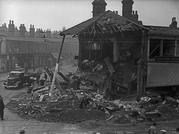 Workmen shift through the crater and basement of the Hereford Hotel, Villa Cross