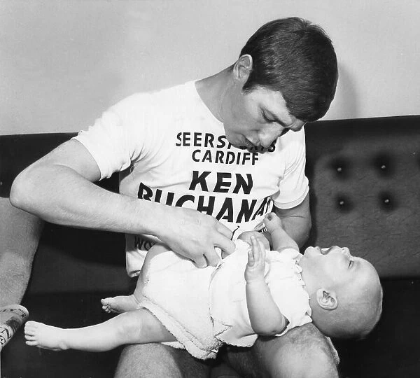 World Lightweight Champion Ken Buchanan seen here tending to his young son Mark during a
