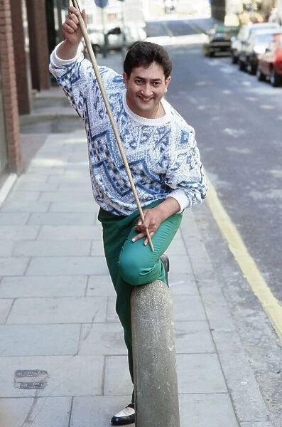 World snooker champion Joe Johnson poses with cue in the street. 28th May 1986