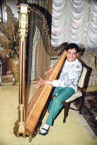 World snooker champion Joe Johnson poses in London, playing a harp. 28th May 1986