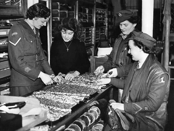 World War II Women: L  /  Cpl Joy Barber measuring out a length of cloth behind the counter