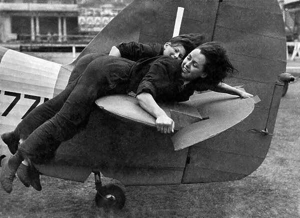 World War II: Women. WaF girl mechanics lying on the tail of a Hurricane fighter