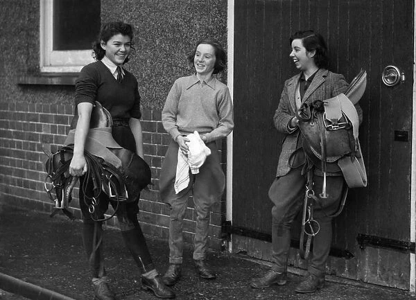 World War II Women. Three women in the land army prepare to go riding after a hard days