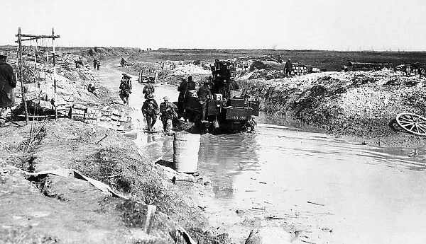 World War One mobile anti-aircraft gun is driven along a flooded road beside an