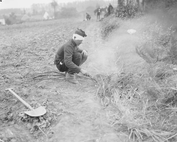 A wounded Belgian soldier lights a fire in a field close to the town of Haelen