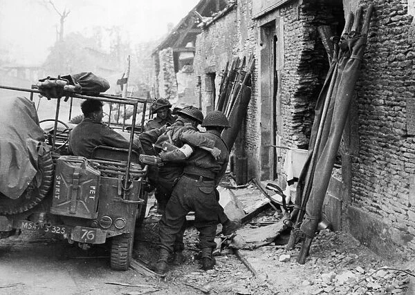 Wounded being loaded into jeeps during the capture of Caen. 9th July 1944