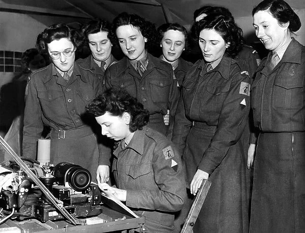 WRACs (Womens Royal Army Corps) gather round a teleprinter for instructions