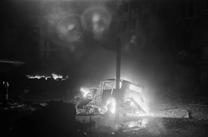 Framed Print : The wreckage of a car a blaze after being hit by a bomb