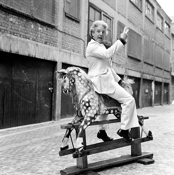 Wrestler Jackie Pallo poses with a rocking horse. February 1975