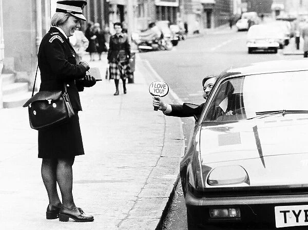 Writer Bryan Rimmer shows a traffic warden his sign. Local Caption ecard01