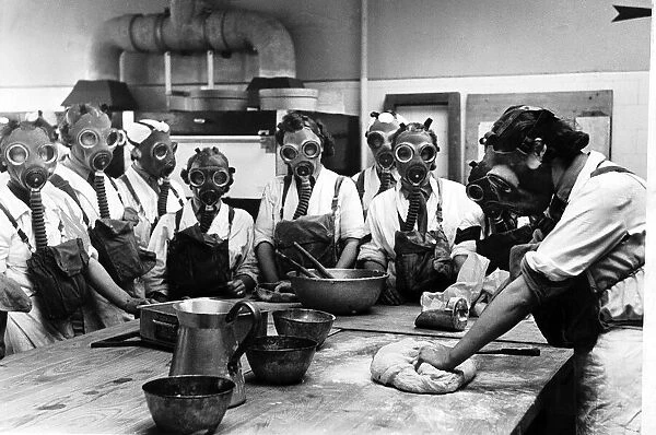 WW2 Army cookery school, June 1941. Women wearing gas masks while watching a