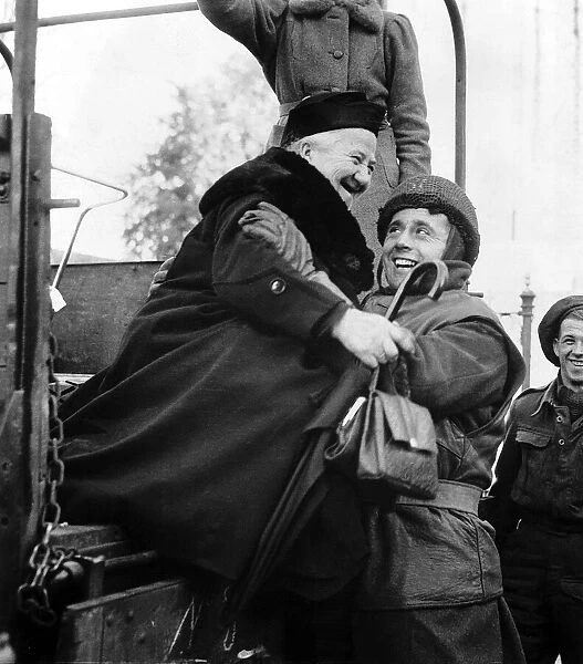 WW2 A British soldier helps an elderly Dutch evacuee down from an army lorry