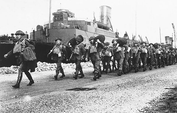 WW2 British soldiers disembark from a troop ship in France carrying their kit bags