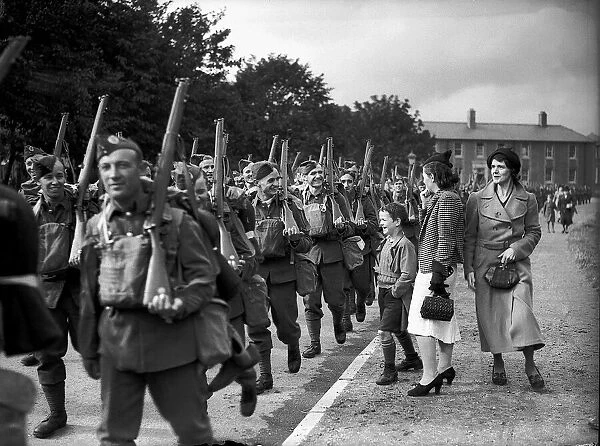 WW2 British Soldiers in England march along the road past family