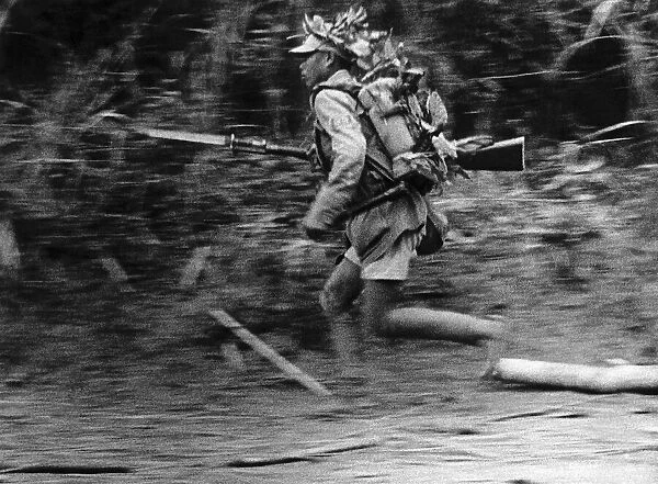 WW2 Chinese infantry soldier advances along a roadside in Burma