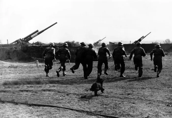 Framed Print : WW2 The crews of an anti aircraft gun battery run to man their guns followed by their