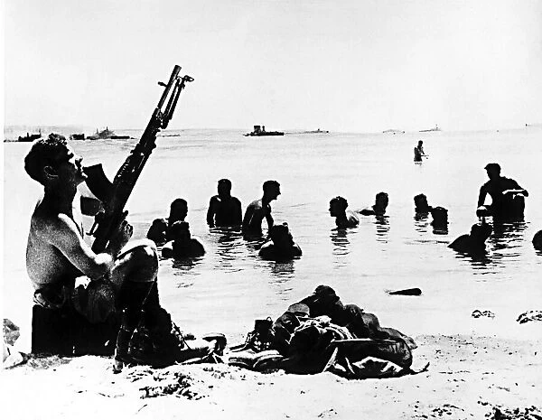 WW2 Machine gun protection for soldiers from the 8th Army as they wash in the sea