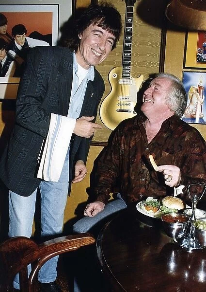 Bill Wyman serves Jimmy Jones comedian at Sticky Fingers restaurant. May 1989