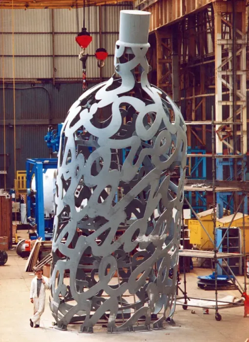Framed Print : Yard electrician Peter Gilpin is dwarfed by the huge 35 foot metal bottle ordered by Framed Print : Yard electrician Peter Gilpin is dwarfed by the huge 35 foot metal bottle ordered by
