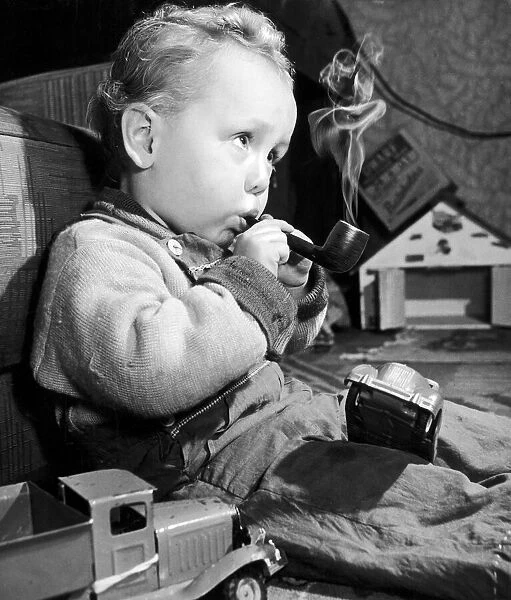 Two year old Bobby Spain of Westgate-on-Sea smoking his pipe. 9th May 1952