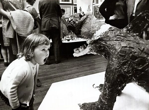 Three year old Cheryl Thomas looking at a sculptured monster at the National Exhibition